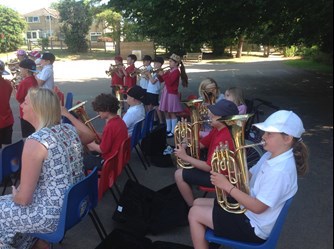 A photo of the tuba players sat down as they play their instruments during the Stratton Primary brass concert
